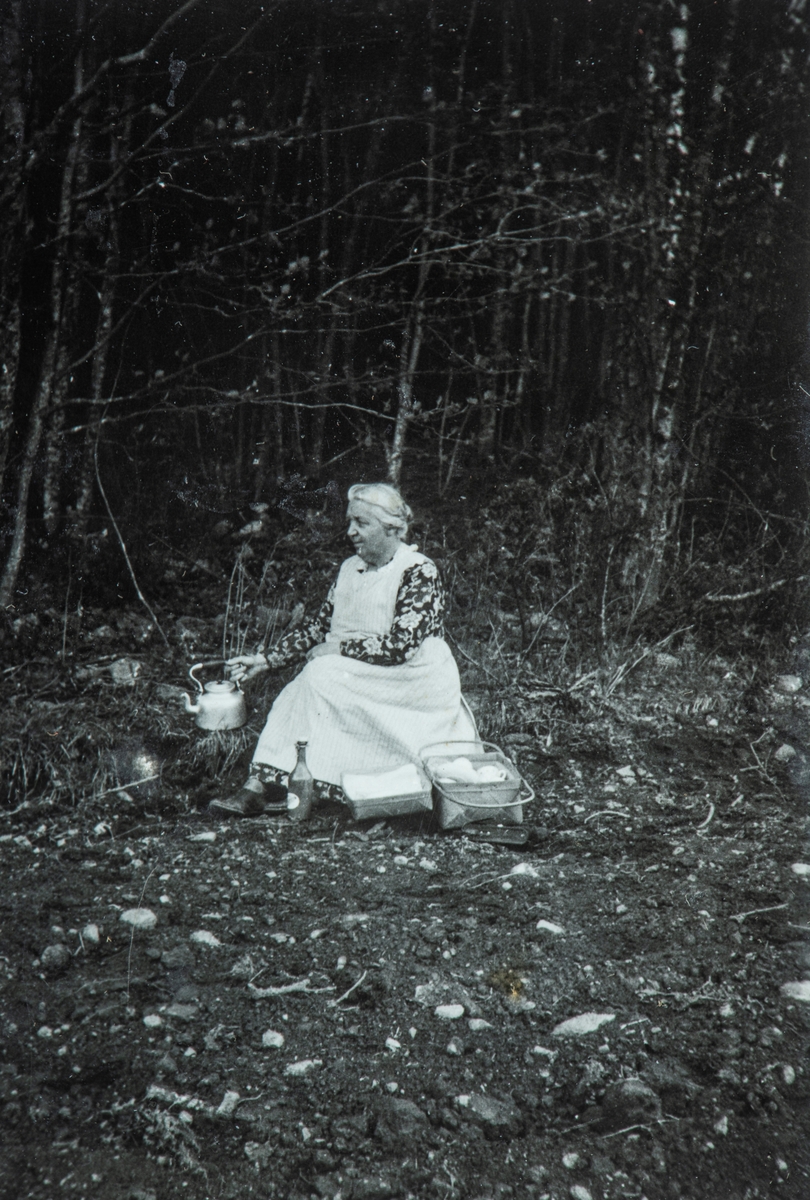 Karset (63/1). Helga Karset med kaffekjele og korg med kaker. Hun kom ofte med æftaskaffe til arbeidsfolket ute på jordet på Karset.