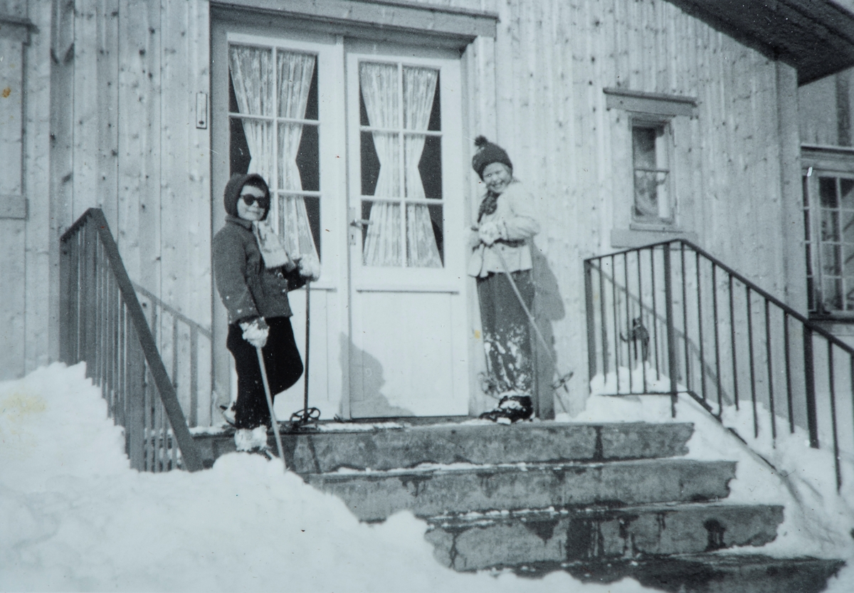 Øvre Tomter (60/1). Foran den nye verandaen på Øvre Tomter. Solveig Hagen og Ragnhild Prestrud.  Vinteren Ca. 1960.