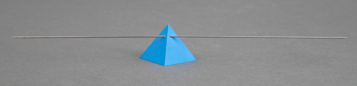 Nålen er satt sammen av en blålakkert messingspyramide og stålnål som perforerer pyramiden. Når brosjen festes på klær skal nålen bøye seg slik at den går i en bue.