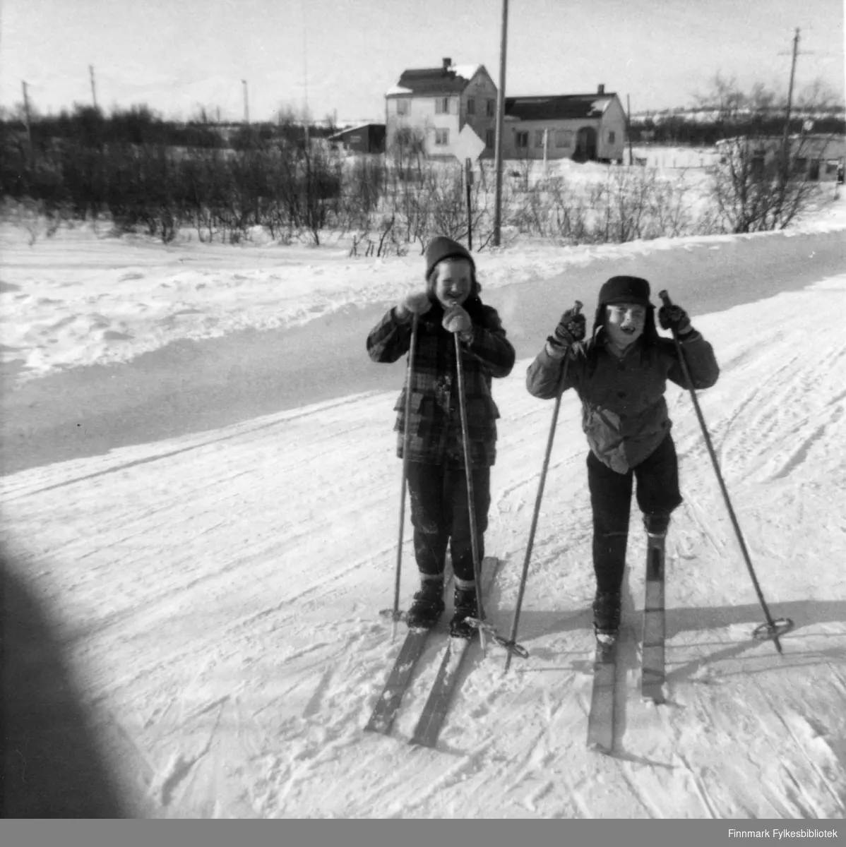 Fra venstre Svanhild Karlsen og Arnfinn Moen. Bildet tatt ca. 1959-1960. Bak ser vi kafeen og bensinstasjonen som den gang ble drevet av Einar Manninen, senere overtatt av Terje Nilssen.