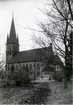 Alnö kyrka. Kyrkan invigdes 1896 och ersatte då en kyrka av trä som brunnit ner efter 25 år. Detta är en nygotisk tegelkyrka, ritad av arkitekt Ferdinand Boberg. Kyrkan består av klocktorn, långhus med utbyggnader i väster för trappor till läktarna samt ett polygont kor med sakristia och arkivrum på ömse sidor. Ingången är förlagd i väster genom vapenhuset i tornet. Långhuset har trätak med öppen takstol och koret har tegelvalv.