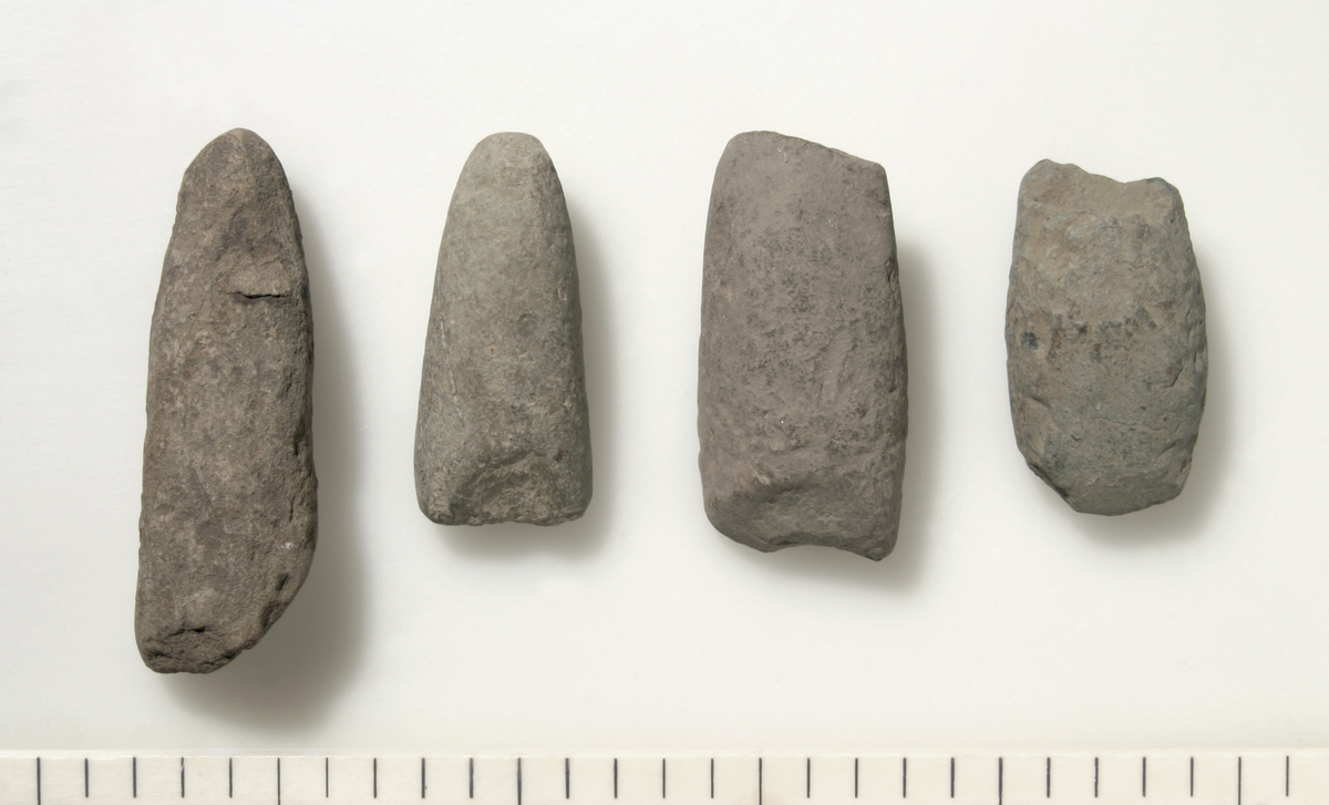 Eggfragment av prikkhugget, rettegget trinnøks av finkornet bergart. Nakken er sterkt ødelagt. Oversiden er utsvunget, undersiden er svakt konkav. Eggen er slipt og noe skadet. Forvitret. Datering: MM.
Mål: L.7,1 cm, stb.4,1 cm og stt.2,9 cm i midten.

