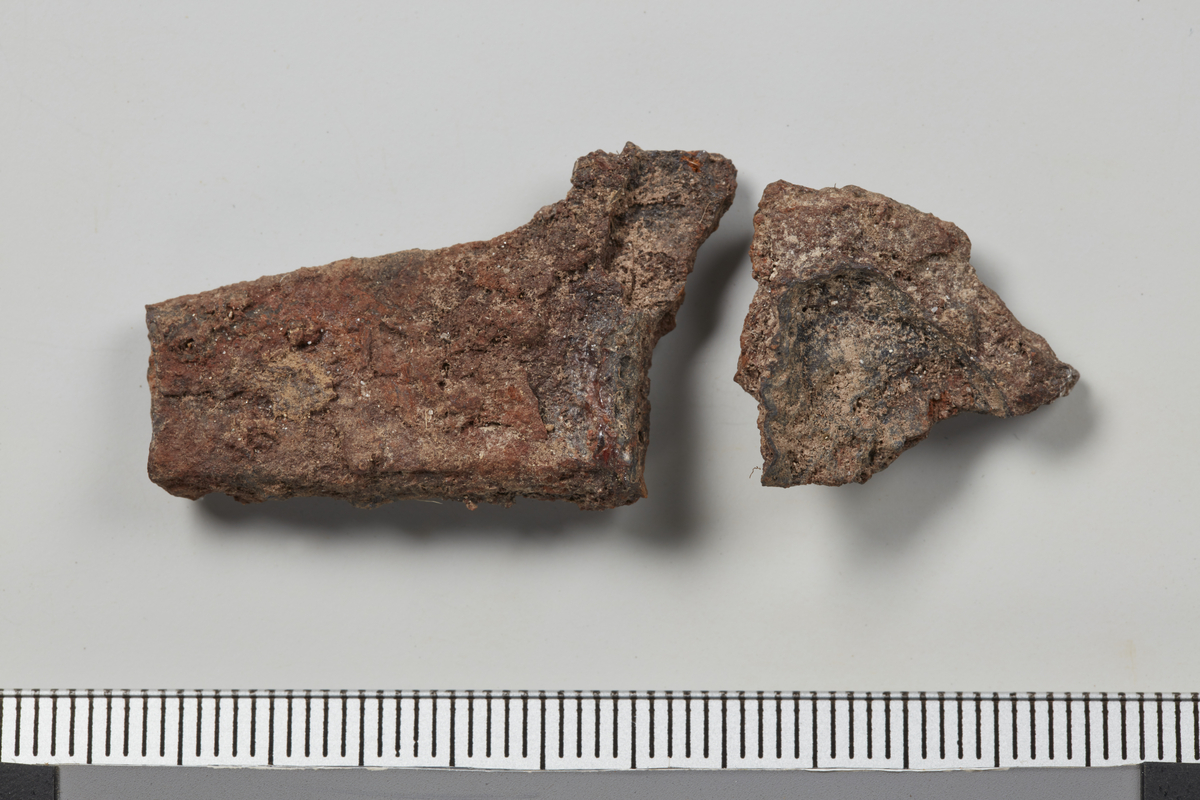 2 fragmenter, passer sammen, trolig del av egg eller lignende. Stl. 4,8 cm, stb. 2cm. Vekt: 6,6 g.