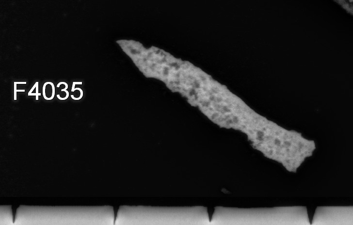 Fragment av kobberlegering. Bruddflate i en ende. Mål: Stl: 2,2 cm. Stb: 0,4 cm. Stt: 0,2 cm. 