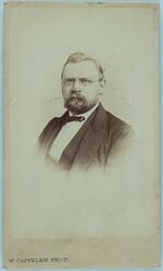 Portrett av mann med skjegg og briller.