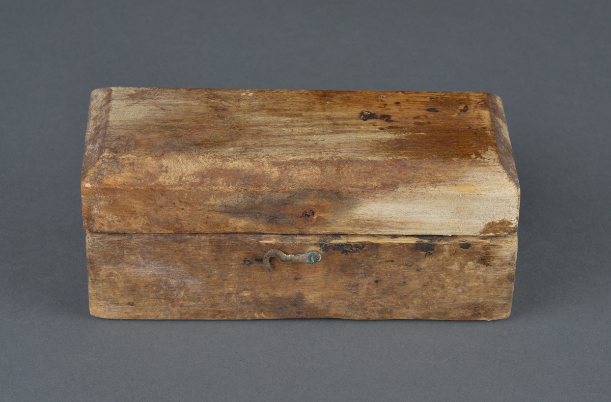 Treskrin med lodd brukt ved veiing. 
Skrinet er rektangulært med innvendig hull for de enkelte lodd.
Av de 11 lodd det er plass for, er bare 4 lodd igjen.
Er hengslet i bakkant (ødelagt) og har en krok for lukking i front. Motsats til kroken mangler, så skrinet består av løst lokk og underdel.