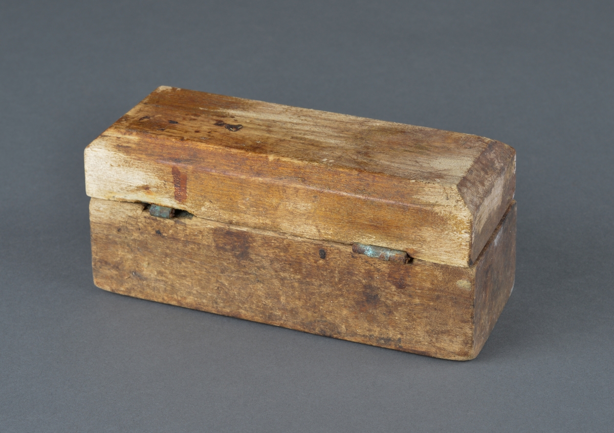 Treskrin med lodd brukt ved veiing. 
Skrinet er rektangulært med innvendig hull for de enkelte lodd.
Av de 11 lodd det er plass for, er bare 4 lodd igjen.
Er hengslet i bakkant (ødelagt) og har en krok for lukking i front. Motsats til kroken mangler, så skrinet består av løst lokk og underdel.