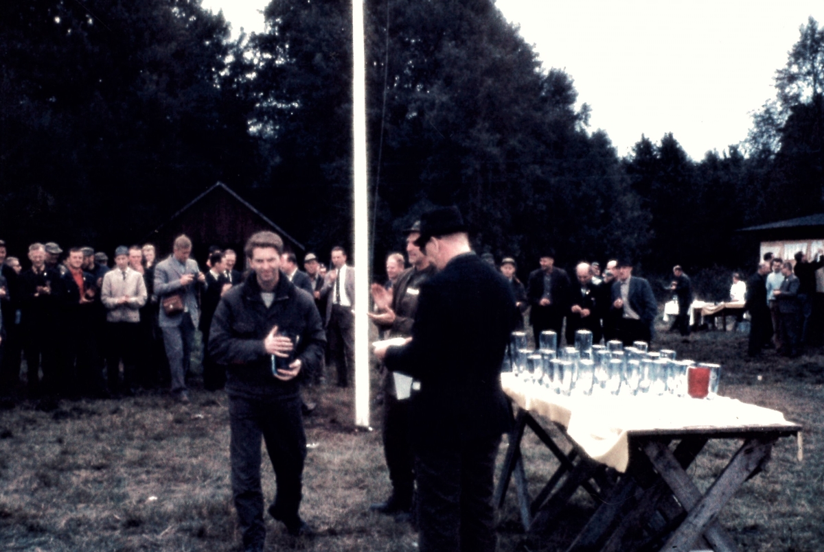 Formgiven av Asta Strömberg. Möjligen modell B1005 (svårt att avgöra). Tjock i godset, blåtonad. Etsad dekor bestående av en logga för en skytteförening och texten "SMÅLANDS MÄSTERSKAPET VÄXJÖ - 1967. Silverfärgad (skadad) etikett med svart text "STRÖMBERGSHYTTAN SWEDEN".