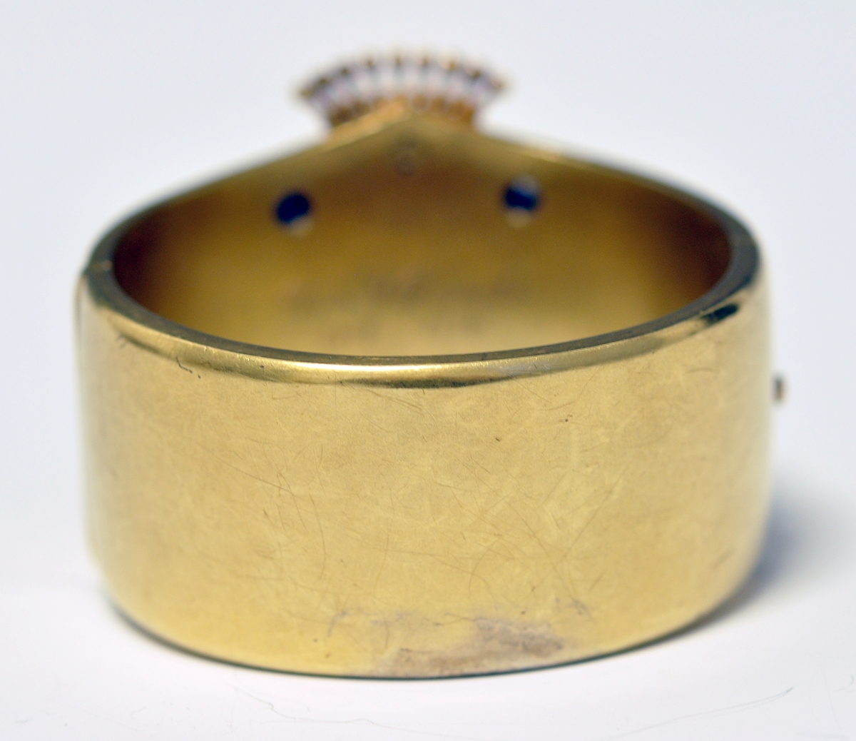 A.Bredt gullarmbånd som kan åpnes  på siden med lås og sikkerhetslenke. Armbåndet går i en spiss foran og det er montert en krone øverst men flere små diamanter, kronen er noe løs. Foran har armbåndet tre lokk  som kan åpnes. Framsiden av lokkene er dekoret med initialer i diamanter :  NWJ. Hvert lokk kan åpnes og inneholder fire fotografier av mannspersoner.Innvendig er det gravert inn årstall og stemplet.

B. Lilla eske smykkeeske som er tilpasset armbåndets form og har lås. Innvendig i lokket er firmaets navn stemplet.