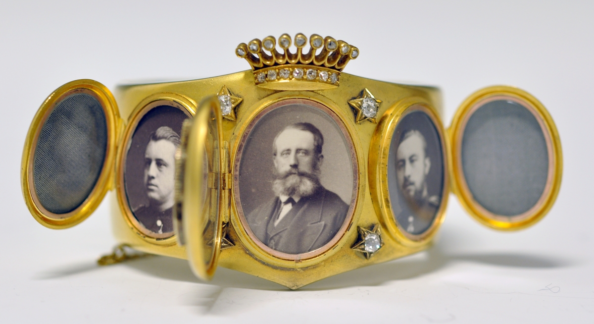 A.Bredt gullarmbånd som kan åpnes  på siden med lås og sikkerhetslenke. Armbåndet går i en spiss foran og det er montert en krone øverst men flere små diamanter, kronen er noe løs. Foran har armbåndet tre lokk  som kan åpnes. Framsiden av lokkene er dekoret med initialer i diamanter :  NWJ. Hvert lokk kan åpnes og inneholder fire fotografier av mannspersoner.Innvendig er det gravert inn årstall og stemplet.

B. Lilla eske smykkeeske som er tilpasset armbåndets form og har lås. Innvendig i lokket er firmaets navn stemplet.