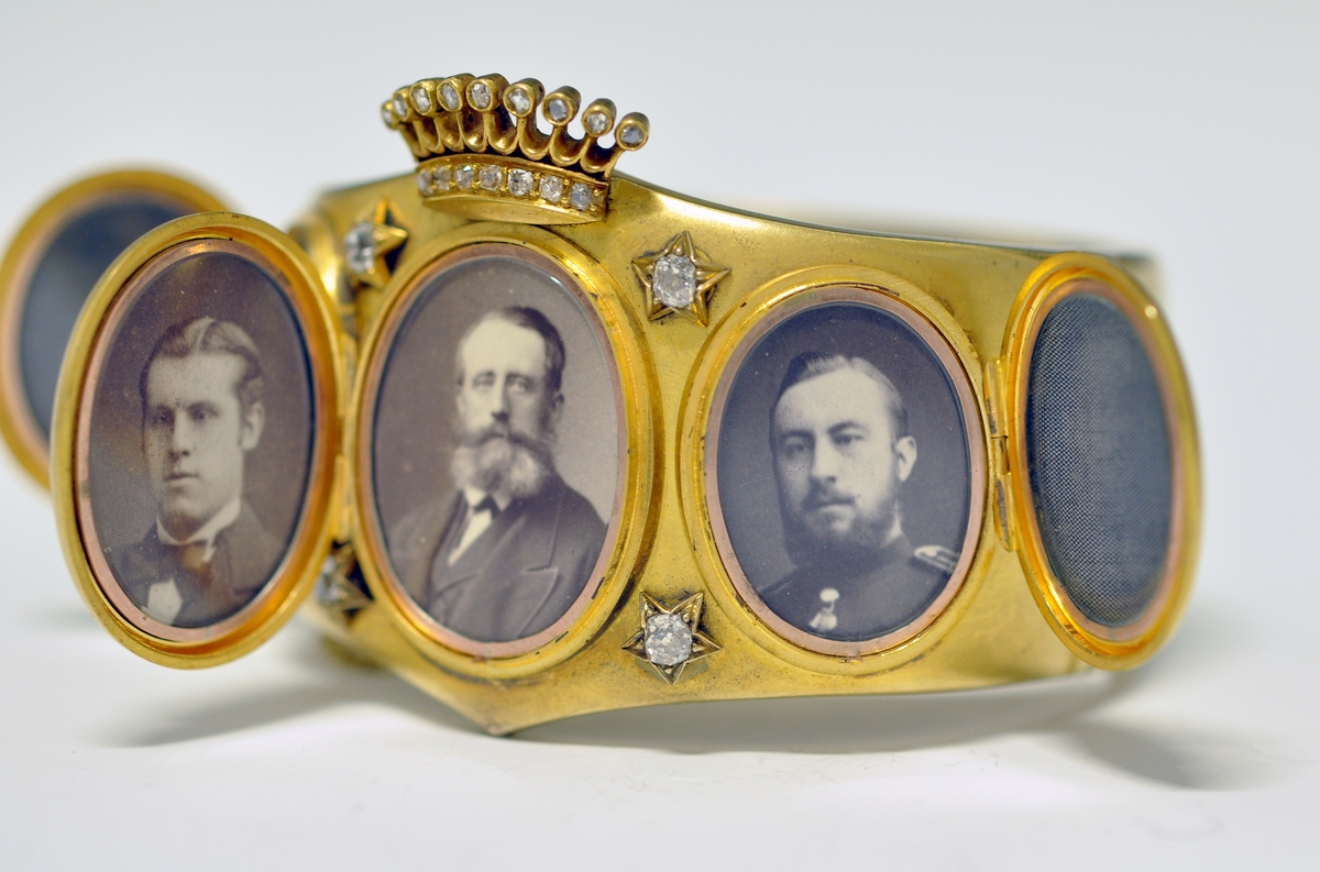 A.Bredt gullarmbånd som kan åpnes  på siden med lås og sikkerhetslenke. Armbåndet går i en spiss foran og det er montert en krone øverst men flere små diamanter, kronen er noe løs. Foran har armbåndet tre lokk  som kan åpnes. Framsiden av lokkene er dekoret med initialer i diamanter :  NWJ. Hvert lokk kan åpnes og inneholder fire fotografier av mannspersoner.Innvendig er det gravert inn årstall og stemplet.

B. Lilla eske smykkeeske som er tilpasset armbåndets form og har lås. Innvendig i lokket er firmaets navn stemplet.