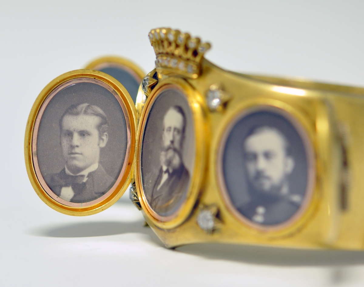 A.Bredt gullarmbånd som kan åpnes  på siden med lås og sikkerhetslenke. Armbåndet går i en spiss foran og det er montert en krone øverst men flere små diamanter, kronen er noe løs. Foran har armbåndet tre lokk  som kan åpnes. Framsiden av lokkene er dekoret med initialer i diamanter :  NWJ. Hvert lokk kan åpnes og inneholder fire fotografier av mannspersoner.Innvendig er det gravert inn årstall og stemplet.

B. Lilla eske smykkeeske som er tilpasset armbåndets form og har lås. Innvendig i lokket er firmaets navn stemplet.