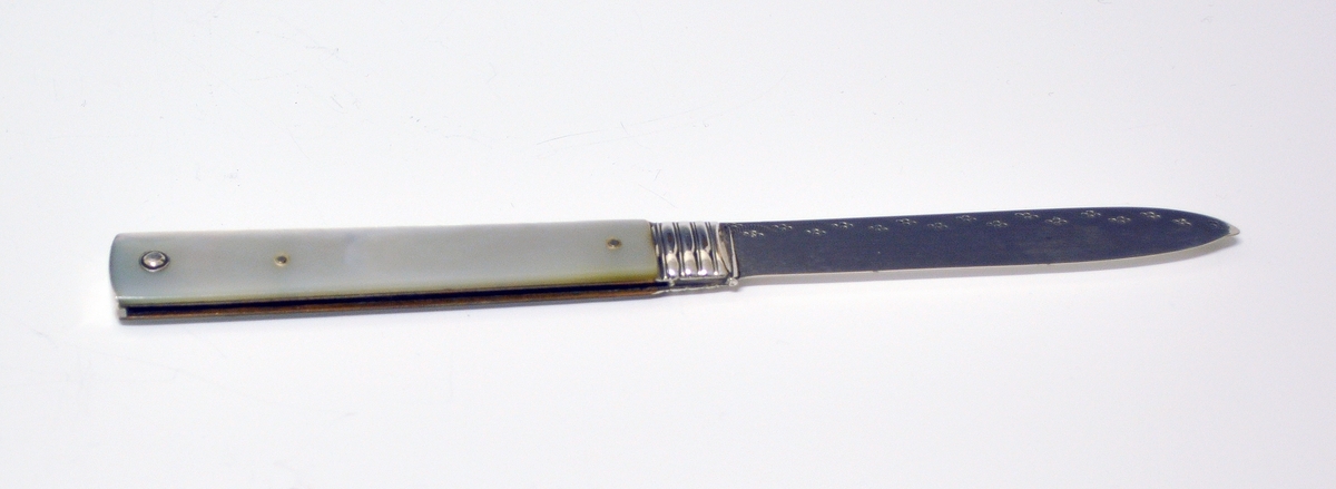 Sammenleggbar kniv i sølv og perlemor. Spisst blad, stiplet bølgeform langs kanten med prikker i mønster. Tre bånd nederst mot skaftet. Skaftet skråner svakt ut med svakt buet avslutning. Stiplet mønster på smalsiden av skaftet. Perlemorsskaft med innfelt, oval sølvplate med initialene BHA.
Stempel: Portrettprofil og løve, England.