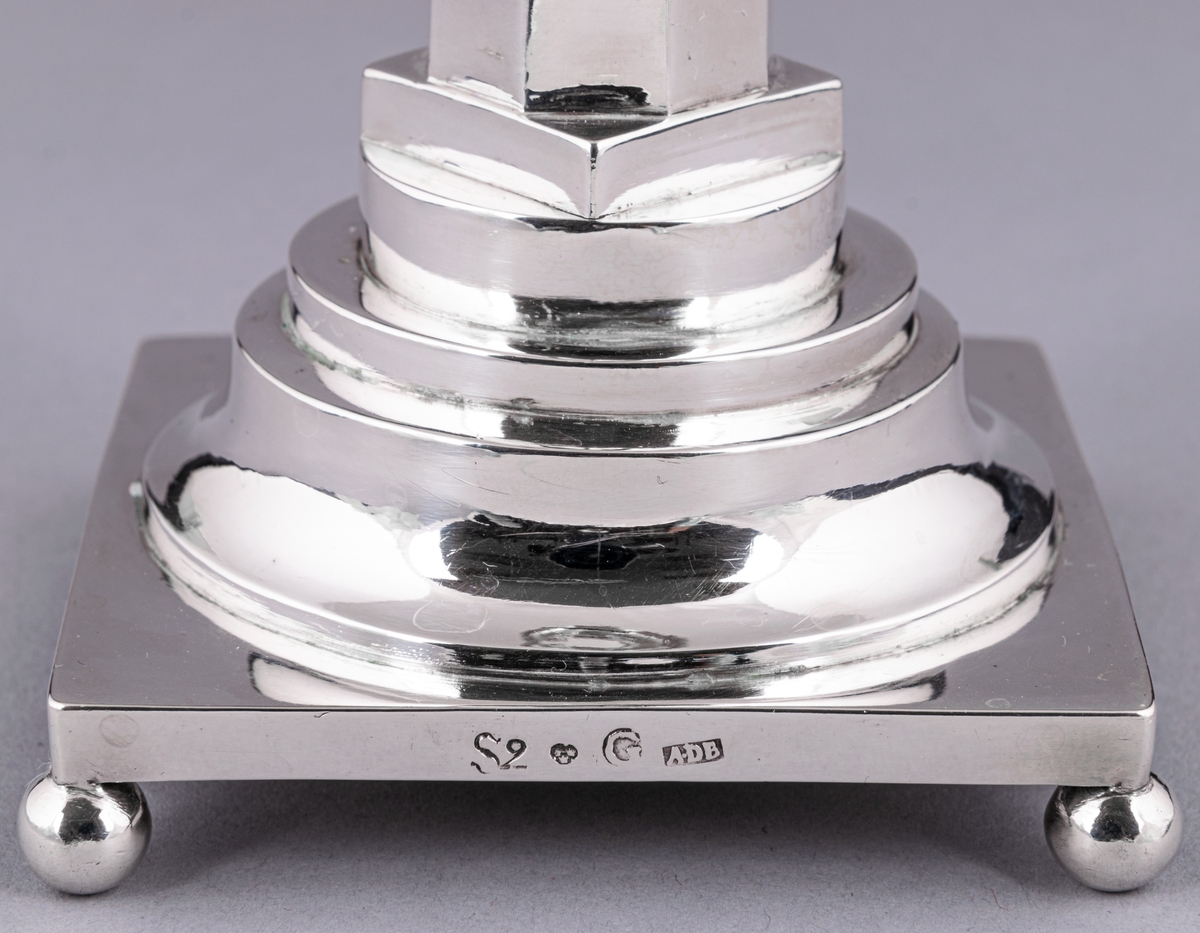 En av ett par gustavianska ljusstakar i silver stämplade Anders Dunderberg, Gävle 1800. Stram åttaformat ben med avtagbar manschett, rektangulär terrasserad fot med kulfötter. Mästarstämpel på fotens sida: S2 tre kronor G A.DB.