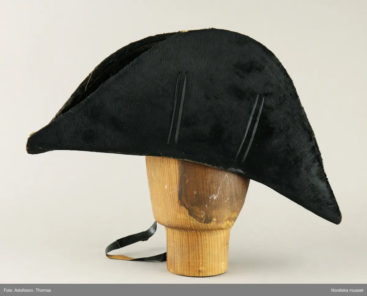 Huvudliggaren:
"Hatt, Kepi m.m.
Tillhört Stockholms borgerskaps infanteri-uniform.
a) Trekantig hatt med plym.
b) Kepi. Märkt: [avtecknat C i dubbelmonogram och XV] med plym.
c) Epåletter märkta: FYRWALD".
d) Huggvärja. Fäste af mässing, med bygel, parerstång och parerplåt, skaften lindad med silfvertråd, knappen urnformig, upptill med platta, för sigill; klingan eneggad och prydd med vapentrofeer m.m. i etsning.
e) 24 knappar.
G. af skomakaren C. A. Hedman i Stockholm. 29/5 1883."