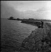 Bilden föreställer en erosionsdal längst med Vätterns strand. Marken är snötäckt och vattnet är isfritt.