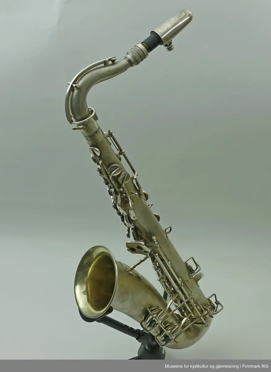 En altsaksofon med kasse produsert i Tyskland av H.G. Hüller. Laget av messing og med enkelt rørblad. Saksofonen har gravert dekor med logo av fabrikkprodusent "G.H.Hüller Saxophonefabrick Schöneck i.V". Saksofonen består av munnstykket, hals og kropp. Den har 24 klaffer med 9 knapper av perlemor. Klaffene er på innsiden dekket av et hvit kunststoff. Nummeret "43311 L" er gravert på baksiden rett ovenfor buen.
