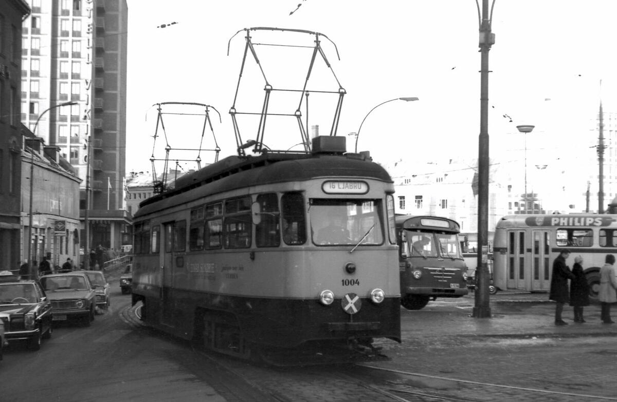 Jernbanetorget i Oslo i 1973. I forgrunnen kan man se Ekebergbanen nr. 1004 på linje 16. Til siden for banen er det to busser og biler. 