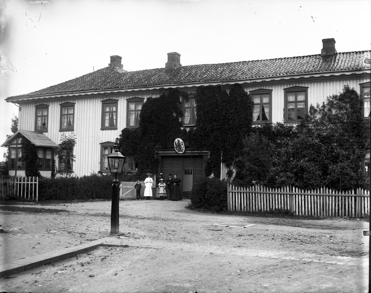 Fotosamling etter fotograf John Nielsen, Porsgrunn. Gruppeportrett avfotografert foran det britiske vise Konsulatet på Nedre Frednes Gård.
