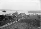 Ett av tiden påverkat fotografi som ändå ger en enastående vy över Högabacken söder om Rimforsa. Året är 1902 och närmast betraktaren ses Sjöstugan, som även burit namnen Strandhem och Mejeriet. Vid tiden för bilden bodde här stenarbetaren Axel Wilhelm Johansson och hustrun tillika mejerskan Anna Olivia Hag. Sannolikt ser vi dem på bilden i kretsen av grannar. I bakgrunden ligger det vitrappade Tävelstad missionshus.