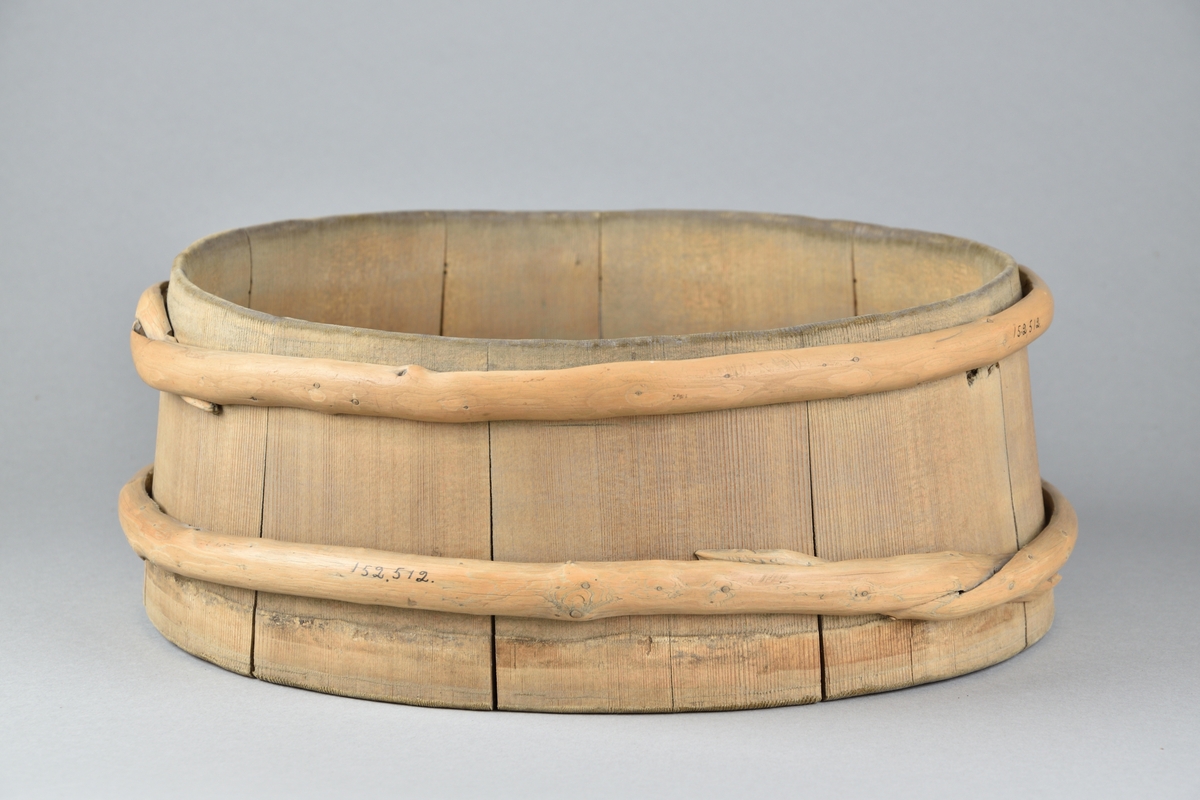 Mjölkbunke tillverkad i trä. Runt laggkärl med tio stavar, samt två utanpåliggande vidjor. 