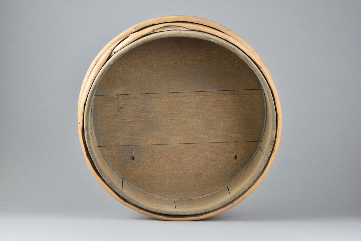 Mjölkbunke tillverkad i trä. Runt laggkärl med tio stavar, samt två utanpåliggande vidjor. 