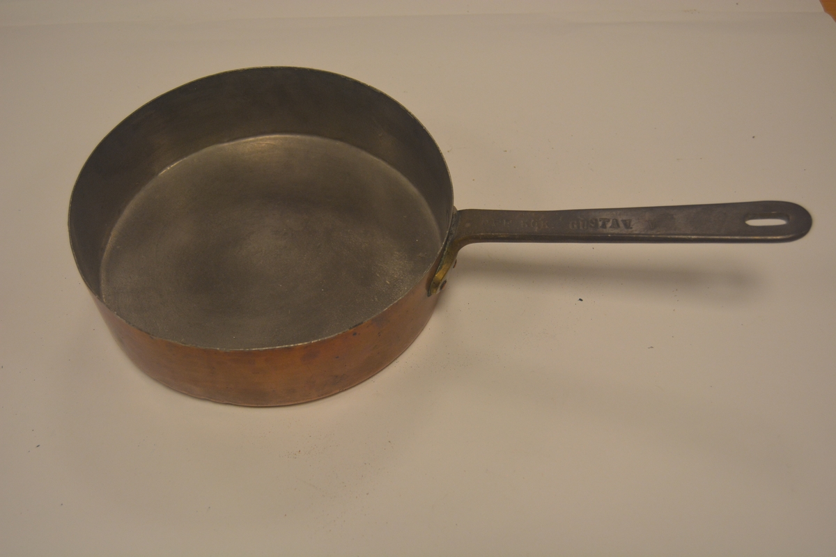 Stekplåt av koppar med handtag.
Märkning: Off.kök Gustav V samt Skultuna 1607  2 L och krona.
Från 1920-talet.