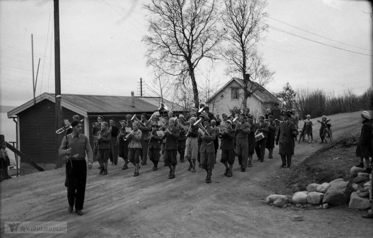 Kvam skolekorps marsjerer i Julsundvegen klare til å svinge opp Bjørsetalleen. .Bjørsetsletta og Bjørsetsaga i bakgrunnen.