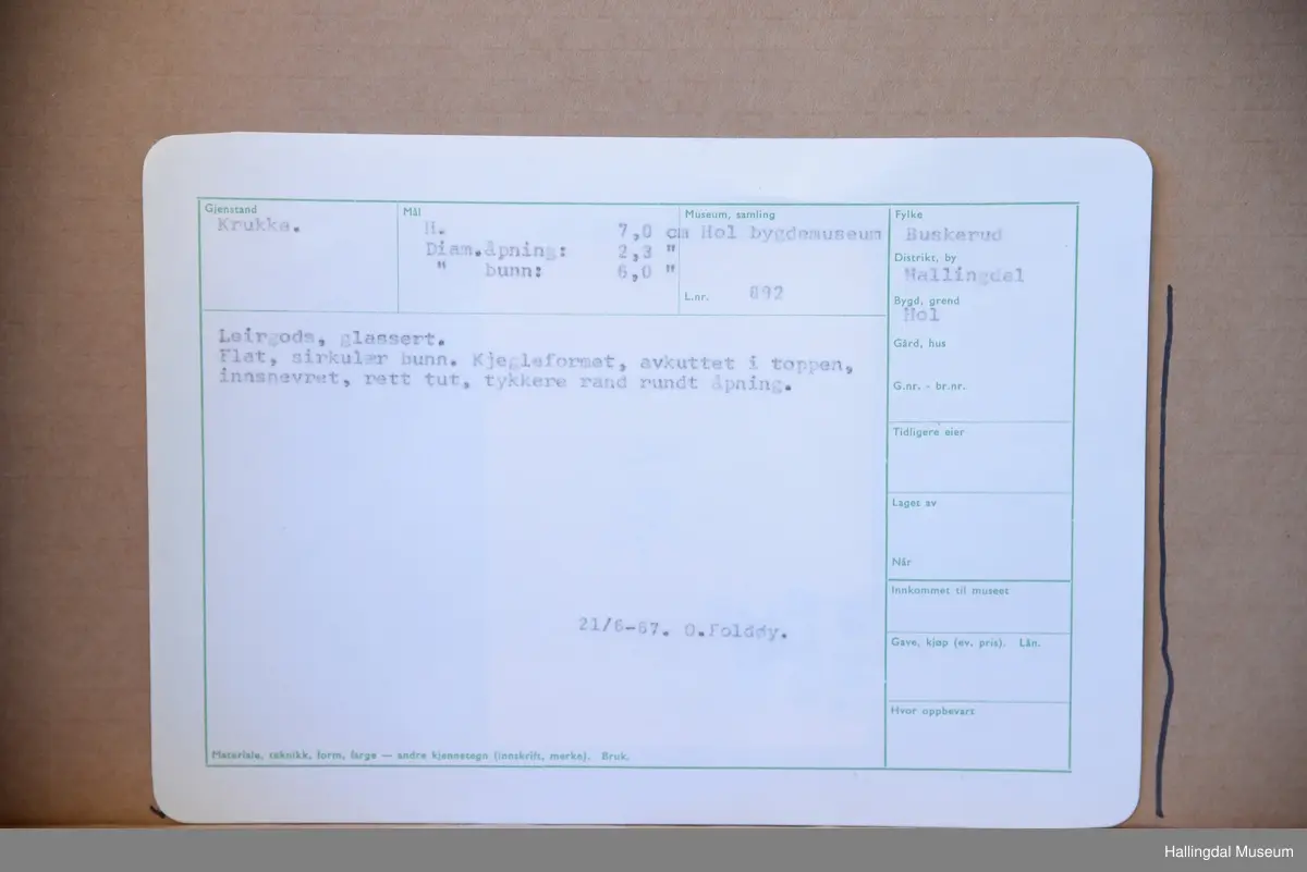 Flat, sirkulær bunn, kjegleformet, avkuttet i toppen, innsnevret, rett tut, tykkere rand rundt åpning.
21/6-67. O. Foldøy.