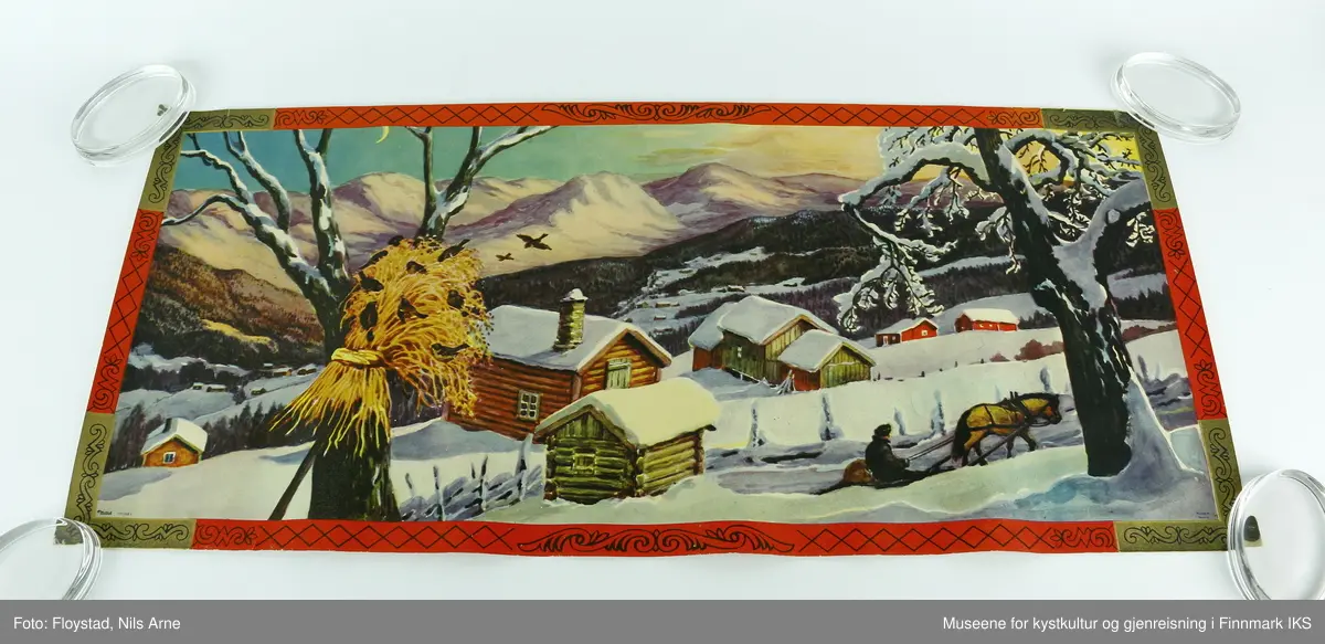 En rektangulær papirplakat med påtrykt vintermotiv av en snødekt fjellgård, et tre med julenek og fugler, en person med hest og slede. I bakgrunnen er det flere andre fjellgårder omgitt av skog og høye fjelltopper. Plakaten har en rød og gullfarget kant med mønsterdekor. Nederst i venstre hjørne står "Mittet 700/008 I", og i høyre hjørne står det "printed in Norway".