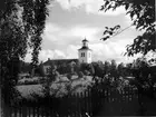 Kyrka. Byggmästare Simon Geting. Nyklassisk stil (tidig). Vitputsad stenkyrka med torn i väster och sakristia i öster. 1823-25 ny predikstol och altarutsmyckning av Johan Edler.