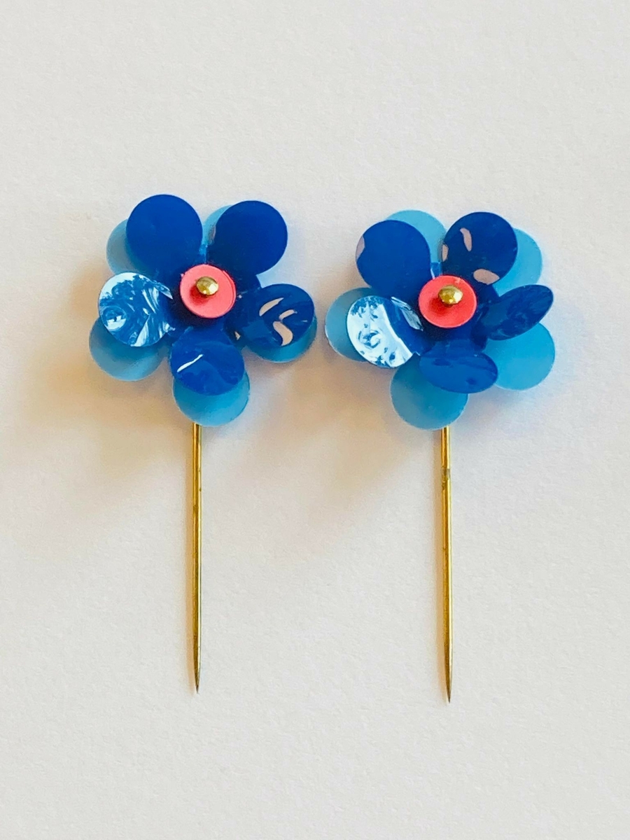 Samlingen består av både enkelte maiblomster og maiblomstkranser (seks små blomster i en ring med nål bak). 
