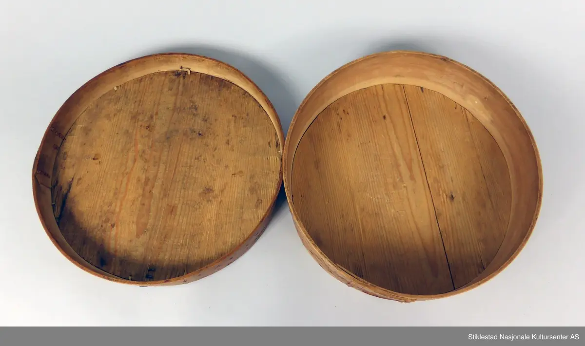 Sveipet øskje med søm av bjørketæger. Innbrent dekor på lokk og sider, rutemønster på side og lokk, 8-kant stjerne. Lokket er forsterket med vinkler av jernblikk. Trenaglene er erstatt med jernstifter