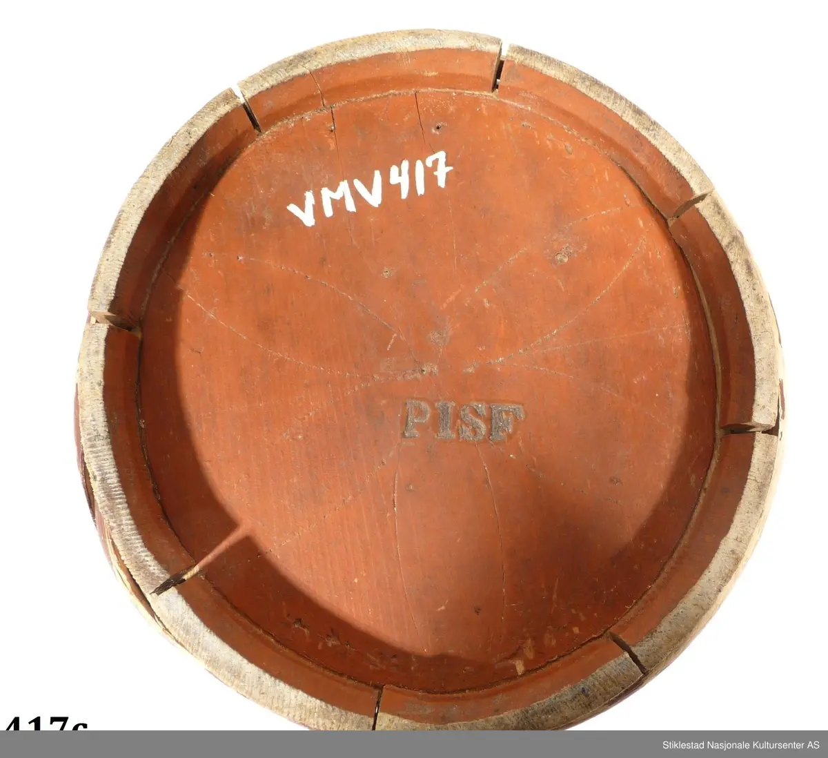 Smørdall i lagget nåletre med fire vidjebånd av bjørk, sylindrisk form. Dallen er malt i en brunrød farge, innskrift i svart.

På lokket er det festet et håndtak av sinktråd. Lokket holdes fast med en "løs" treplugg. Denne festes gjennom hull i ene øret. 
Samme øre er reparert med ei sinkplate pga av slitasje. Initialer og årstall er malt på lokket, under dallen er det ei passer rose, samt merket: PISF.