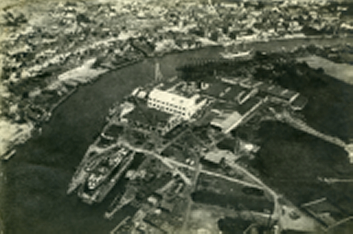Nordre Kråkerøy (nærmest). Bjølstad. Fredrikstad mekaniske verksted (FMV). I bakgrunnen: Vestsiden. Fredrikstad sentrum. Trosvikstranda- Del av Holmen. Evja. Glomma. Vesterelva.