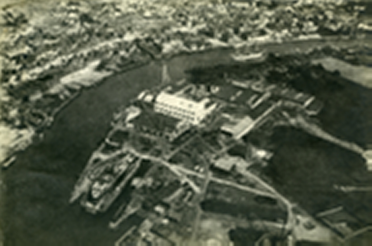 Nordre Kråkerøy (nærmest). Bjølstad. Fredrikstad mekaniske verksted (FMV). I bakgrunnen: Vestsiden. Fredrikstad sentrum. Trosvikstranda- Del av Holmen. Evja. Glomma. Vesterelva.