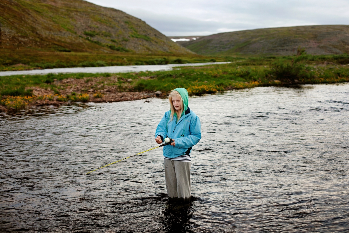 Maria (13) fisker mat til katten i den populære lakseelven Adamselv. [Hentet fra: andreagjestvang.com] Fra serien "Everybody Knows This is Nowhere".