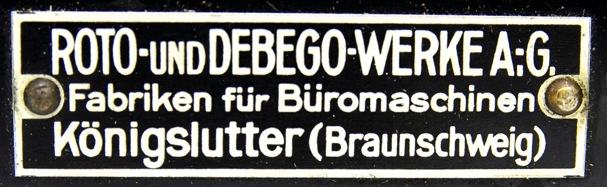 Kopieringsapparat Roto, modell äldre. I svartfärgad metall. Kopieringsapparaten har en tillverkningsskylt med texten: "ROTO-UND DEBEGO-WERKE A;G. Fabriken für Büromaschinen Königslutter (Braunschweig)". Apparaten är nedmonterad i tre delar. Till detta hör även en emballerad origingalförpackning med kopieringspapper av typen "Foolscap Indestructible Stencils No. 102 (417.45)" innehållandes 48 ark. Allting är förvarat i en trälåda märkt med "1572".