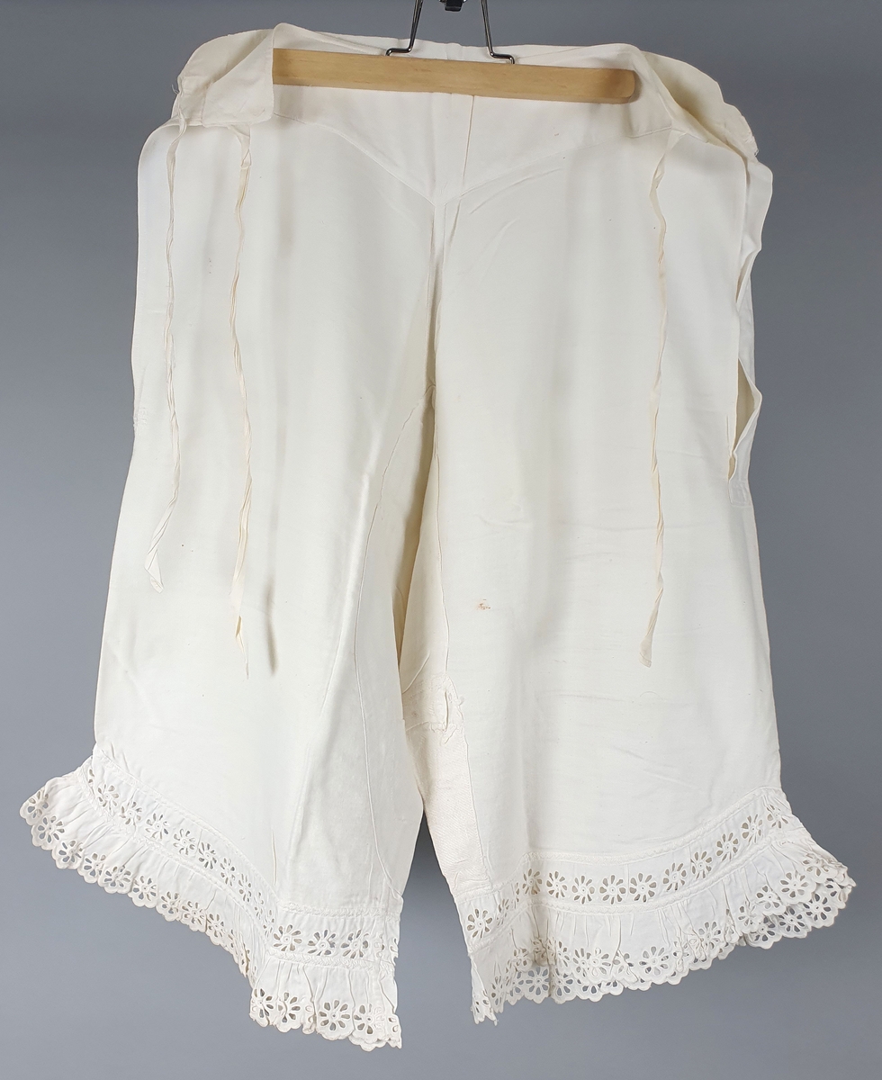 Seks like mamelukker av bomull, med blondekanter på begge ben. Åpning i sidene med knytebånd i linningen. Brodert monogram "A" i linningen. Mamelukkene er i ulik grad slitt og lappet.