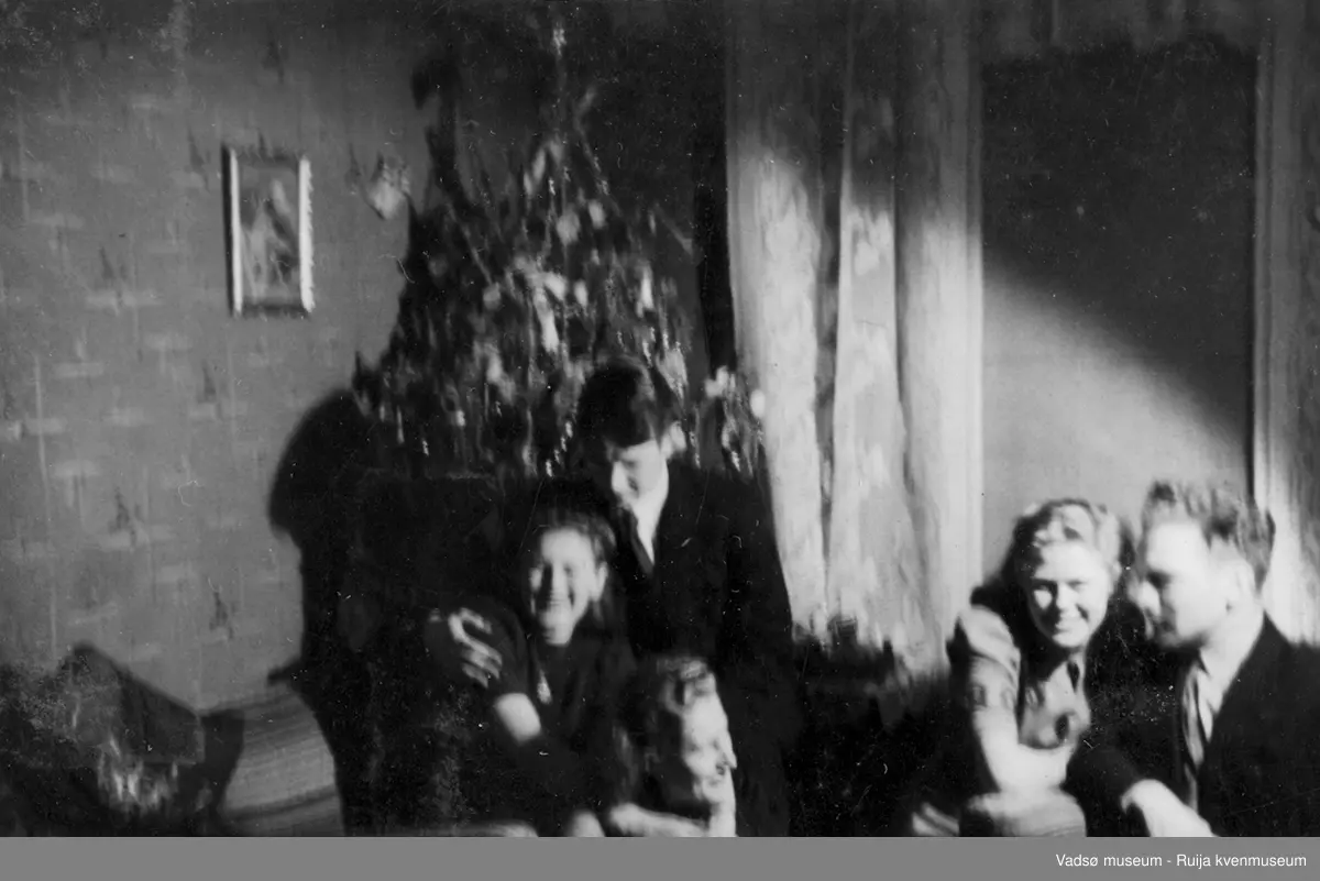Dresskledde unge kvinner og menn avbildet under det som ser ut som en privat sammenkomst nyttårsaften 1941-42.
