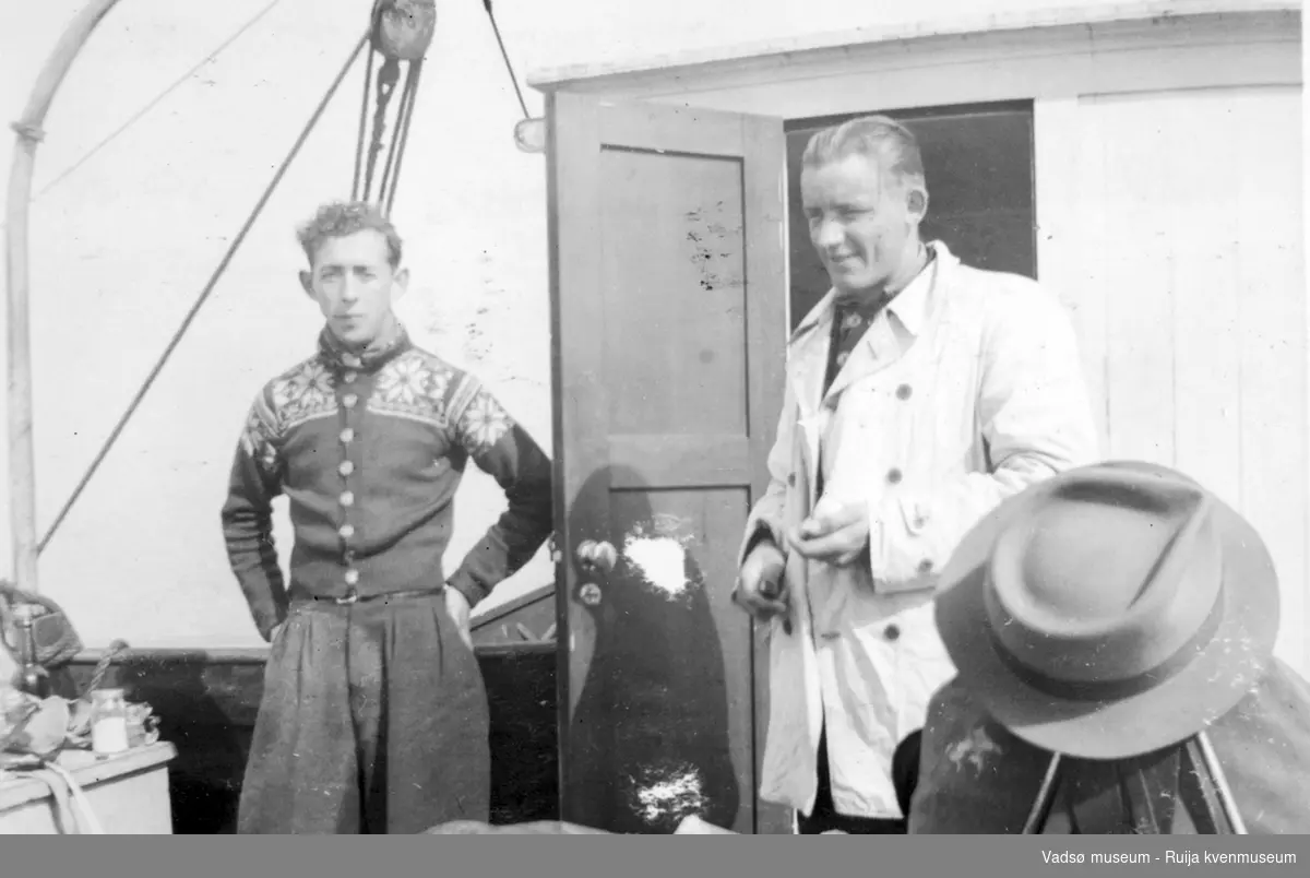 To menn ombord i båt, ant. skøyte. Under transport fra Tromsø til Vadsø, 1943.