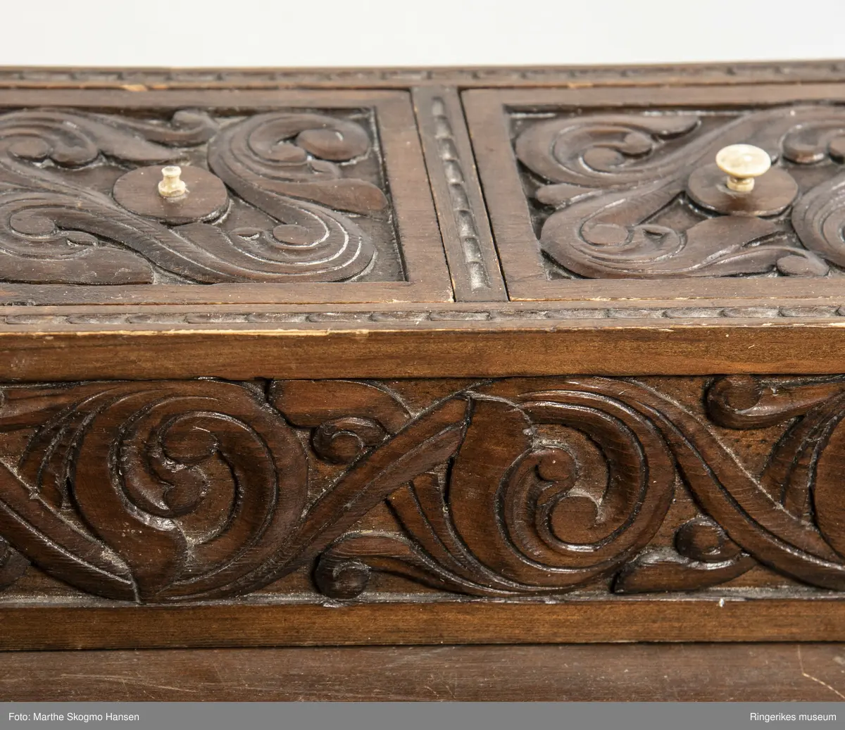 LIte bord med to skuffer og en boks på toppen. Fronten på skuffene, sidene på bordet, og boksen på toppen er skåret ut i tradisjonelt norsk akantusranke-mønster. Beina er skåre ut med geometriske mønstre på alle sider. Bordplata har en øvre del med rette kanter, men så buer den seg utover, så undersiden av bordet er større enn oversiden. Skuffene har håndtak av metall. Boksen er delt i tre rom med lokk. Lokkene er også skåret ut i samme mønster. De løftes ved hjelp av små håndtak, muligens av elfenben. To av disse er ødelagte. Boksen har helt tydelig vært festet i bordet, det er spor etter festene på hver side av boksen, og på baksiden av bordet er det skåret inn to hakk, et på hver side av boksen, disse er ca. 7 cm brede. I hver av disse hakkene står en bøyd, rusten spiker. På høyre side, sett forfra, har den biten av bordet som skulle vært på utsiden av hakket forsvunnet. Siden festet har blitt borte, er boksen nå løs. 