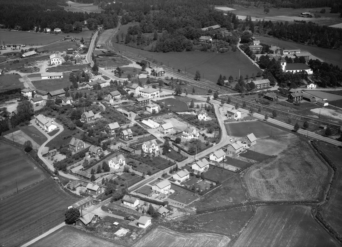 Flygfoto över Ringarum. Orten fick ett uppsving när järnvägen mellan Söderköping och Valdemarsvik stod klar 1906. Vid tiden för bilden var järnvägen ännu i bruk men skulle komma att läggas ned innan decenniet var till ända.  Vy mot Norr.