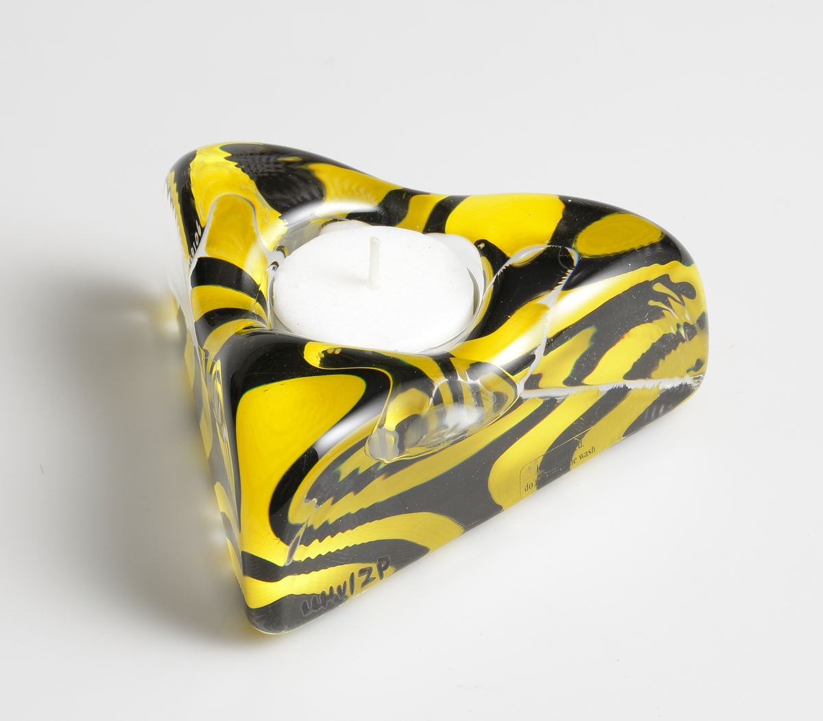 "Piece of Cake" formgiven av Ulrica Hydman Vallien. Trekantig ljusstake för värmeljus. Botten målad i svart och gult.