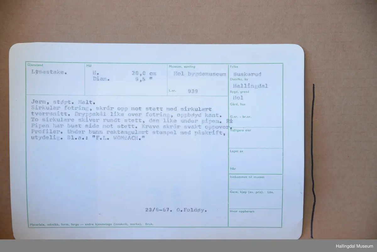 Sirkulær fotring, skrår opp mot stett med sirkulært tverrsnitt. Dryppskål like over fotring, opphøyd kant. To sirkulære skiver rundt stett, den ene like under pipen. Pipen har buet side mot stett. Krage skrår svakt oppover. Profiler.
23/6-67 O. Foldøy.