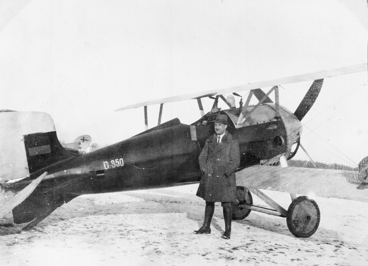 Tyskt jaktflygplan Siemens-Schuckert D. IV demonstreras på Malmen i januari 1920. En man står framför flygplanet. Eventuellt är mannen flygföraren Bruno Rodschinka.