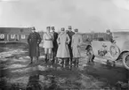 Gruppfoto av militärer på Malmen vid franskt besök, omkring 1917-1920. Från vänster: Gösta von Porat, fransk officer, oidentifierad, Karl Amundson, Ernst Fogman. oidentifierad. Flygkompaniets bil med förare och två hundar bredvid.