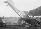 Arbete med flygplan Thulin FA nr 874 som tippat över vid landning på Flygkompaniet på Malmen, omkring 1919-1922.