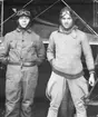 Två flygarklädda män står framför ett flygplan i en hangar på Flygkompaniet på Malmen, 1920-tal.
Mannen till höger är militäre flygföraren Gustaf Stiernspetz.