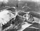 En flygsoldat inspekterar resterna av havererat flygplan på Flygkompaniet på Malmen, 1920-tal.